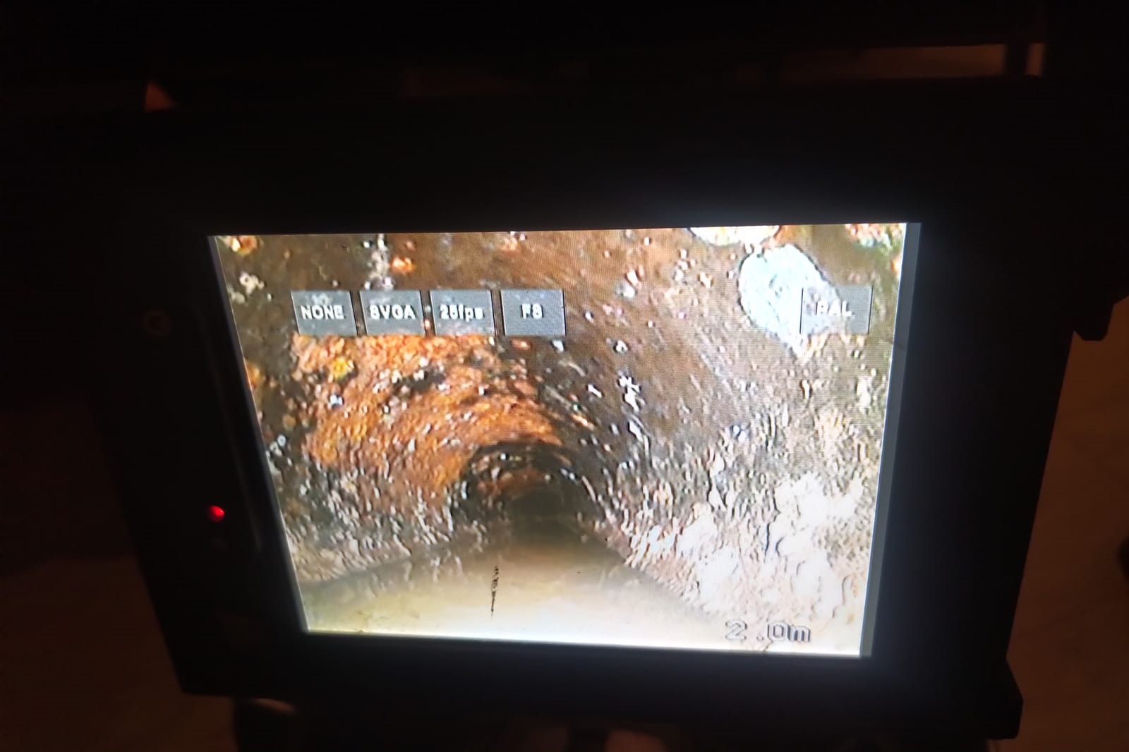Écran de la caméra d’inspection montrant l’intérieur encrassé d’une canalisation